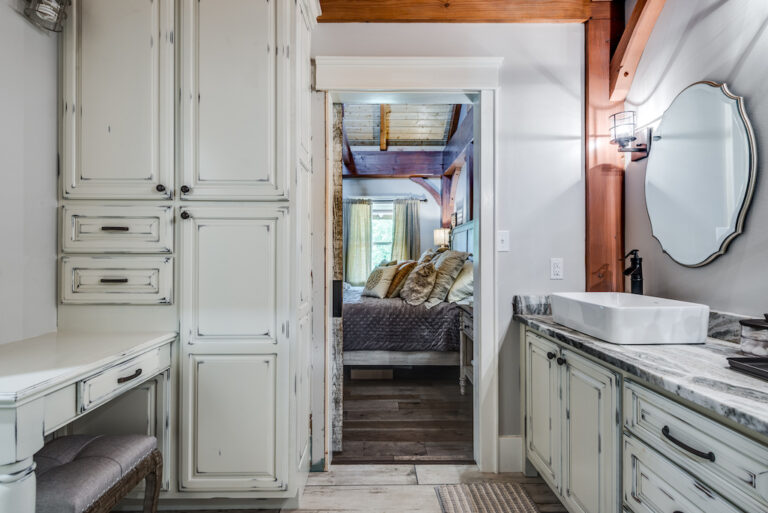 photo of master bath with distressed cabinets, and barn doors