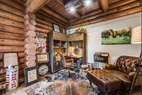 home office tucked into a corner with round exposed wood log walls